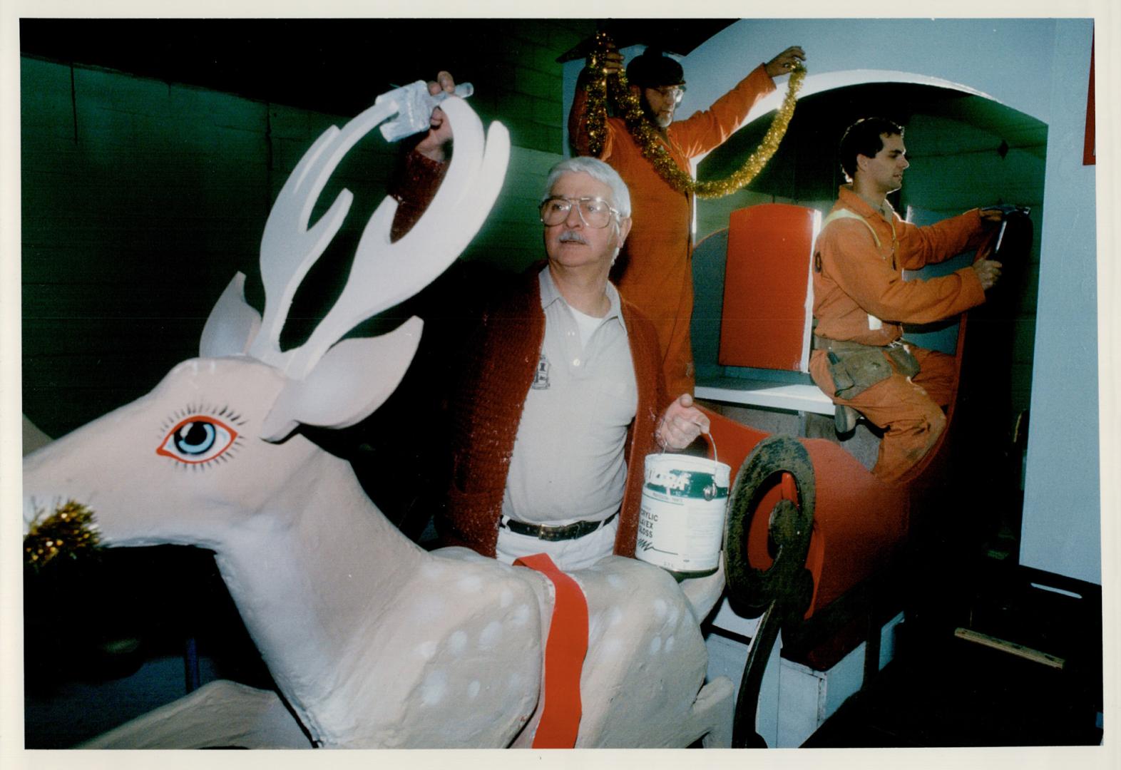 Santa's coming: City workers Henning Rasmussen, Geoffrey Emery, centre, and Brent Melanson work on a float for the Christmas parade