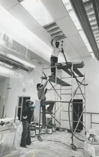 Cleaning up: Gas-masked workers seal asbestos-covered beams in Sir Oliver Mowat Collegiate in Scarborough