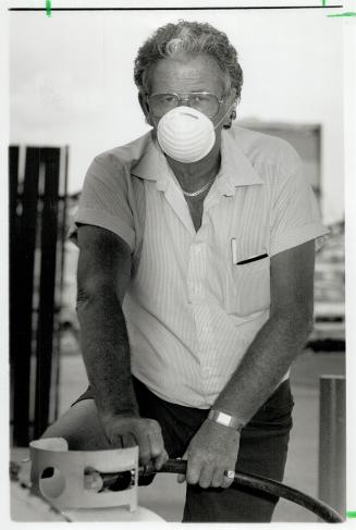 For protection: Carl Macfarlane, a propane pump attendant at a Canadian Tire station, wears a mask on windy days for protection from recycling plant's sawdust