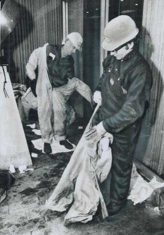 Anti-contamination suits are donned by hydro workers Terry Godfrey (left) and Ron Tasker before they start repairs on transformer after Adelaide St. f(...)