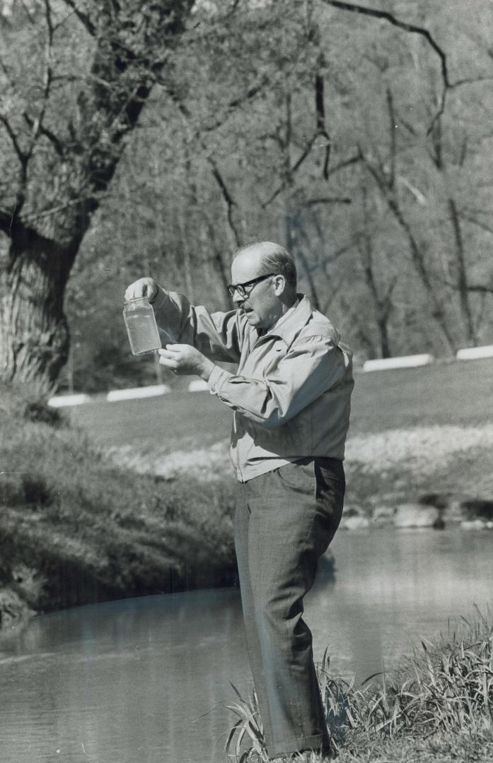 A Sample of water is taken from the west-branch of Don River yesterday by Mayor William Dennison, to be sent to a laboratory for a pollution test. May(...)