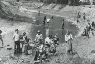 Wading in the water and scouring along the banks with rakes and plastic garbage bags, a group 30 York Mills teenagers and housewives does a spring cle(...)