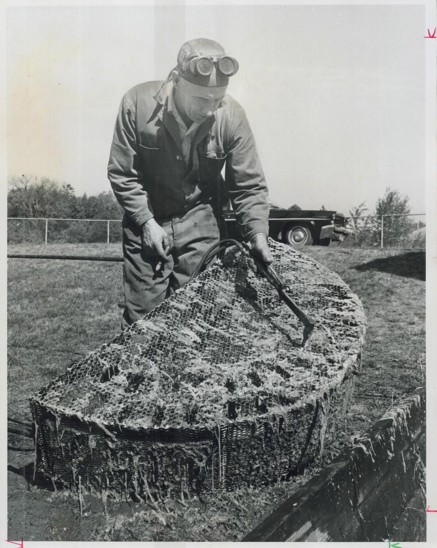 Cleaning-the hard way. A workman at the Cumber Pumping Station on Morningside Ave. cleans filter of a sewage pump with blow torch. The city is finding(...)