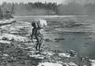 Workman Trudges through heavy oil with material to start a fire