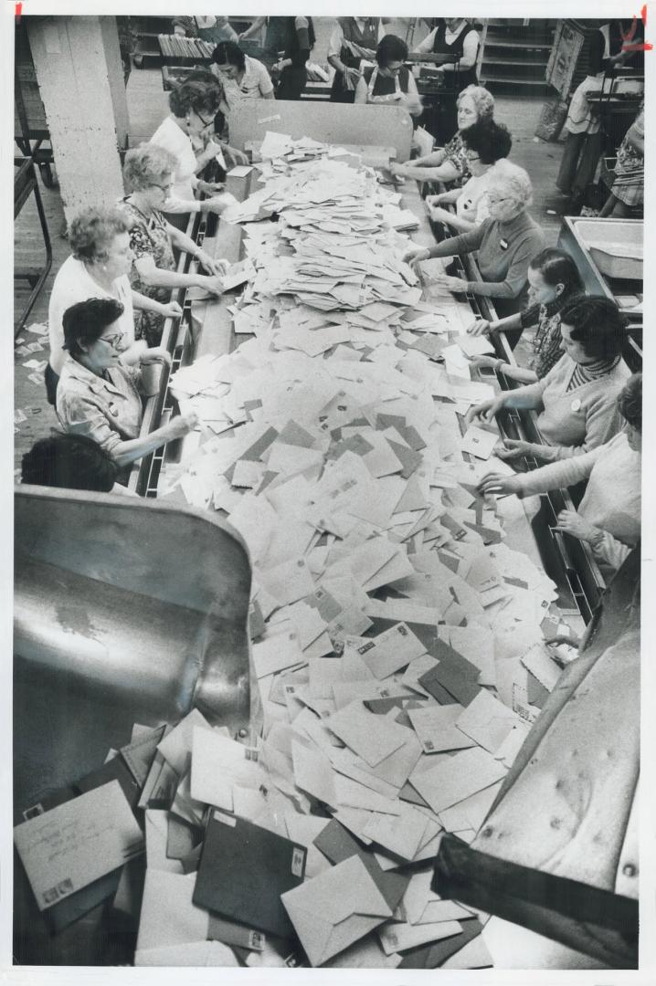 Letters and Christmas cards are sorted along the sides of a conveyor belt