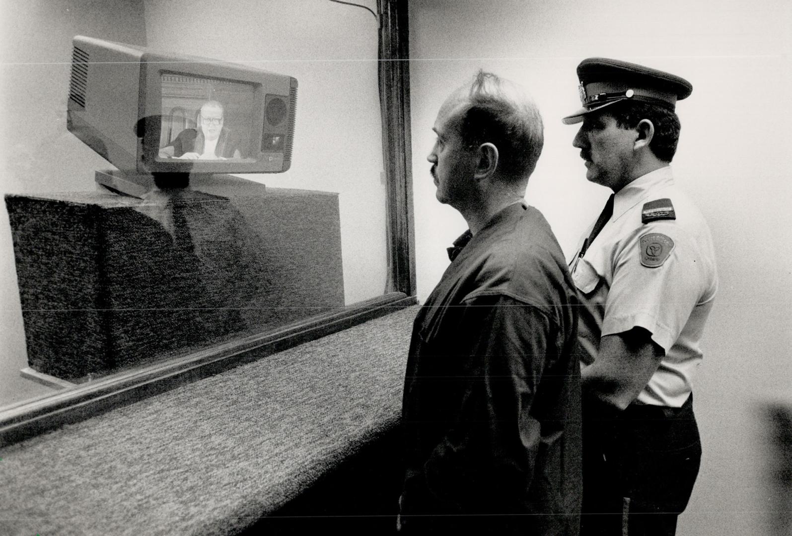 A Video remand: Constable Dave Penney plays a prisoner, accompanied by Court Officer Supervisor Bruce Petley, in test of video link between jail and court