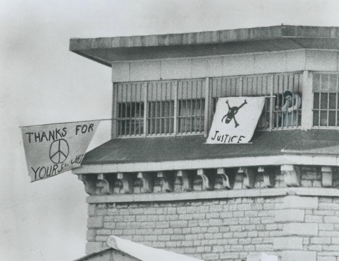 Prison-made banners flutter from barred cell windows of Kingston Penitentiary on Saturday as 500 rebellious convicts hold the centre block, with five (...)