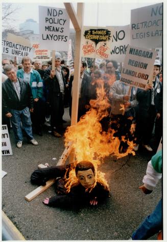 Fiery protest: Demonstrators burn Housing Minister Dave Cooke in effigy at Queen's Park yesterday to protest against proposed NDP rent-control legislation