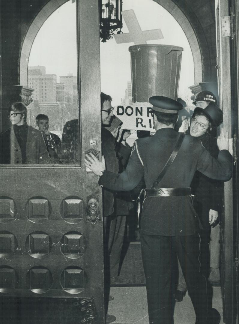 'Mourners' shut out of Queen's park, A guard at Queen's Park shuts the door in the faces of students who tried to hold a mock requiem mass for the dead Don River yesterday