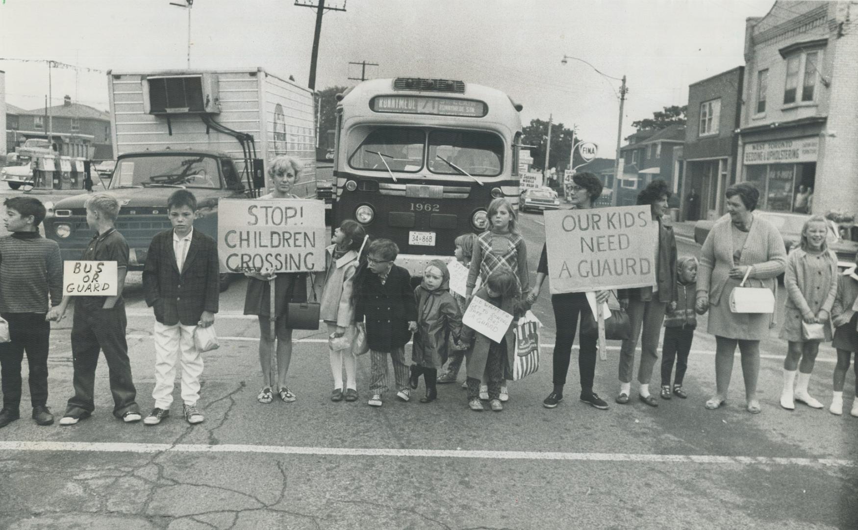 Mothers picket crossing to win a crossing guard, A group of mothers with their children hold up traffic on St