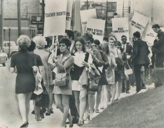 Separate school teachers carrying placards picket the offices of the separate school board yesterday to protest lack of a salary settlement with the board. [Incomplete]