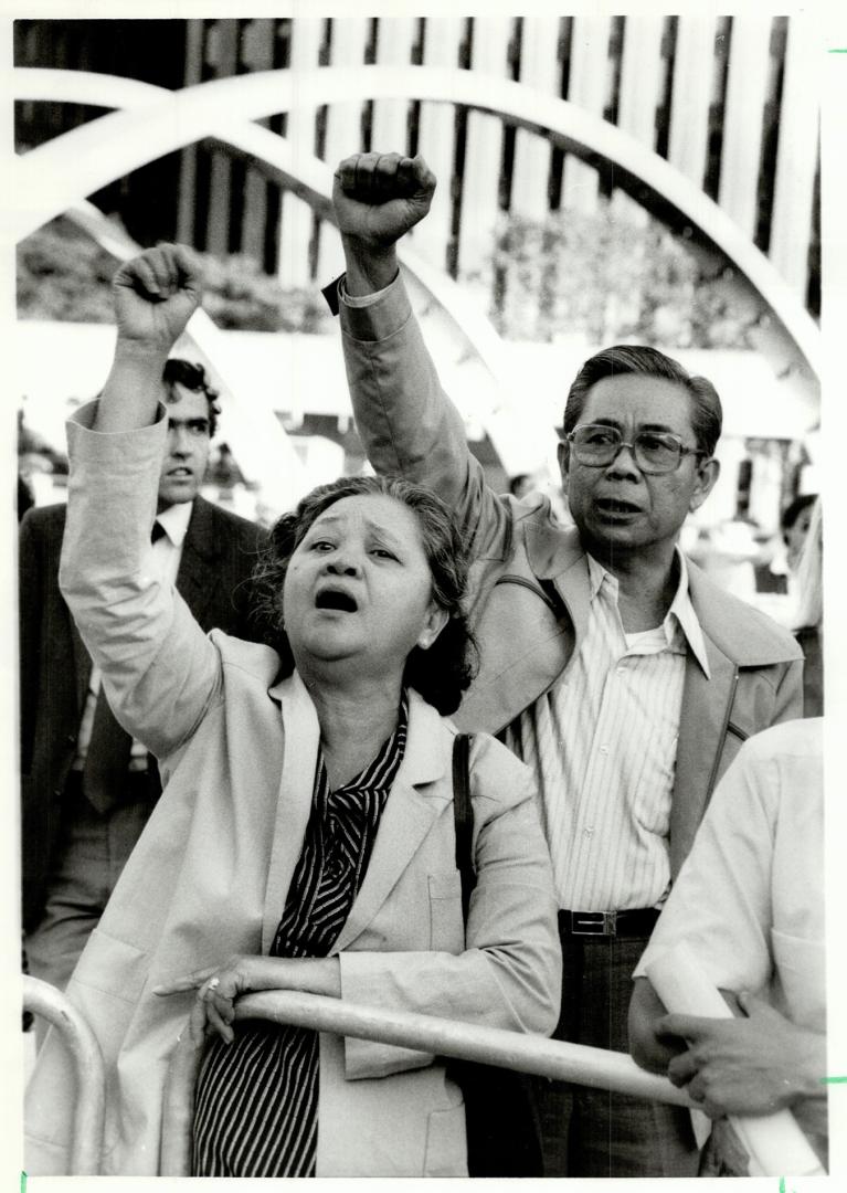 Cries of protest: Couple raise clenched fists in anger during rally at Nathan Phillips Square in memory of Benigno Aquino who was gunned down a year ago when he returned to the Philippines