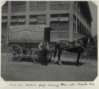 Man stands in front of horse-drawn wagon that says &quot;Made in Toronto, Cowan's Maple Buds ..…