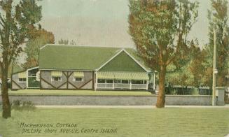 Picture of one storey cottage with verandah with awnings and large front lawn and trees. 