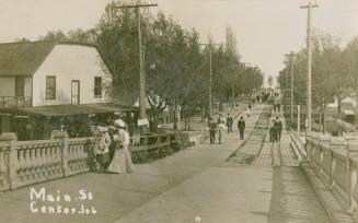 Black and white picture of people walking over a bridge.