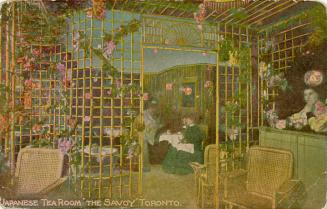 Colorized photograph of ladies having tea behind a bamboo divider.