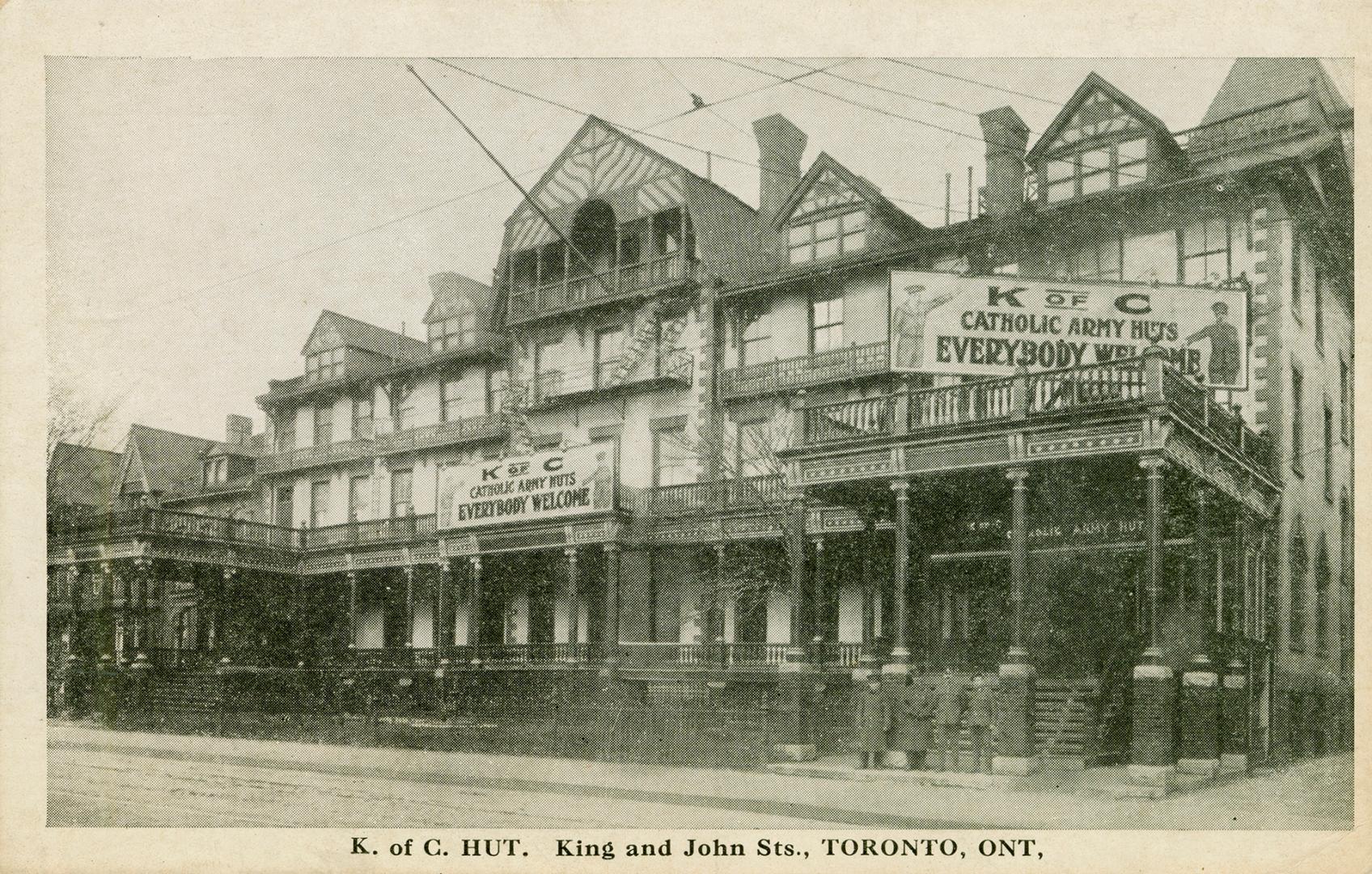 Black and white picture of a large hotel building with signs, &quot;K of C Catholic Army Huts E…