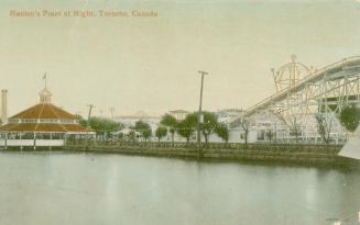 Color picture of a roller coaster beside a pier and lake.