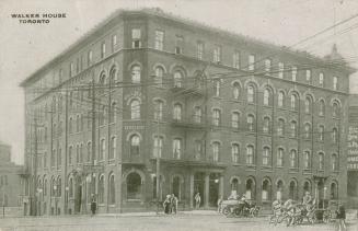 Black and white photo postcard of Walker House Hotel, Toronto. Exterior view. With a few people…