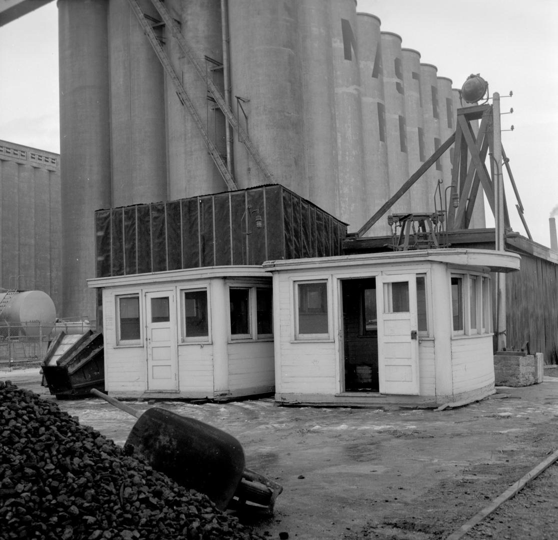 Image shows a few cabins with a part of the factory behind them.