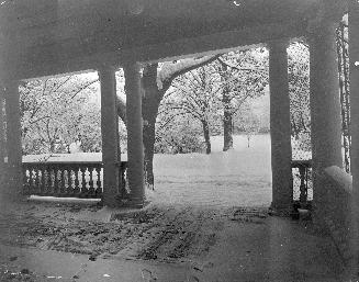 A photograph of the front porch of a house during winter.