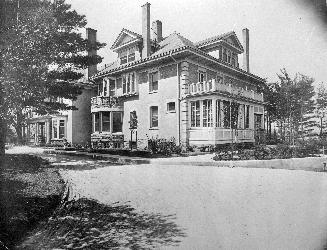 A photograph of a house and a driveway leading to it.