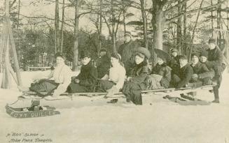 A large group of men and women dressed in everyday clothes on a bobsleigh called Foxy Quiller. …