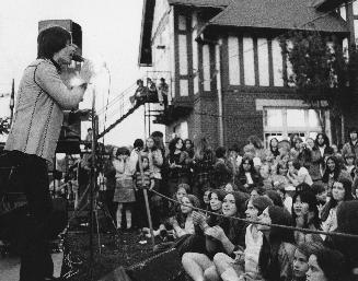 Singer on stage and crowd of children and young people watching