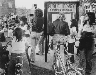 Young people watching an outdoor concert outside Eastern Branch library