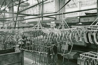 A photograph of workers building washing machines on an assembly line.