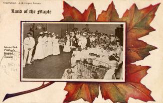 Black and white picture of hospital staff and children assembled in a large room.