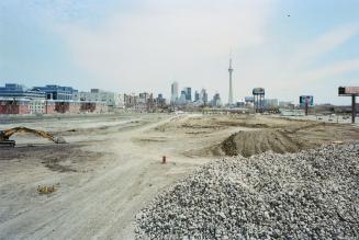 A photograph of a construction site, with a pile of rubble in the foreground and the Toronto sk…