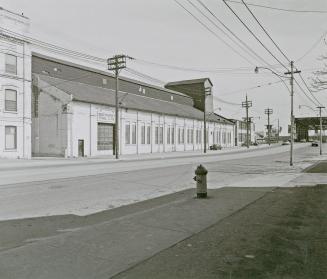 A photograph of a building with a sign reading &quot;Bathurst Tool Ltd.&quot; on the left side …