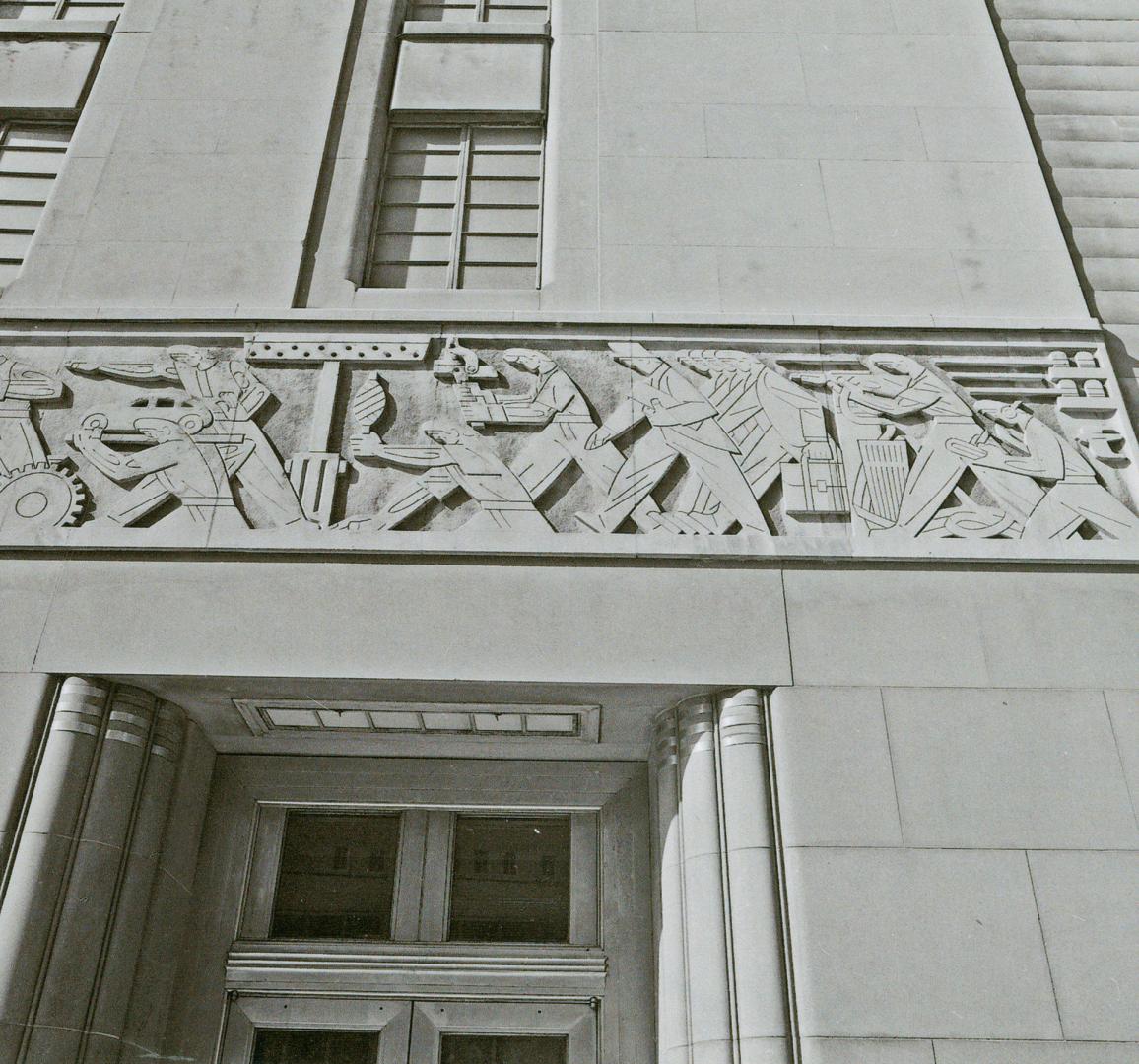 A photograph of a frieze above a doorway, depicting workers in various industries and professio…