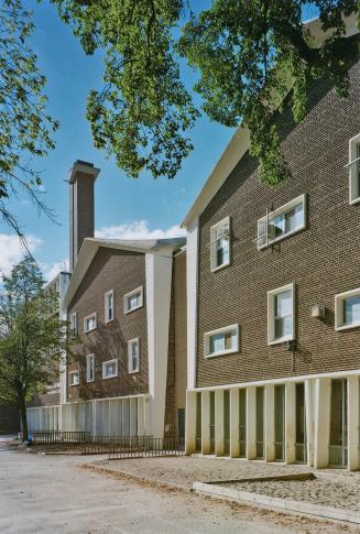 A photograph of the outside facade of a public school with windows.