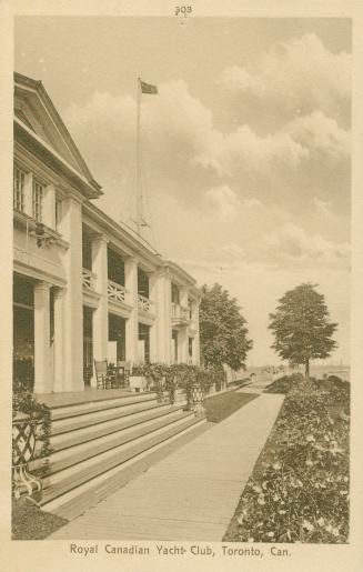 Sepia toned photograph of the front of a large building with a verandah.