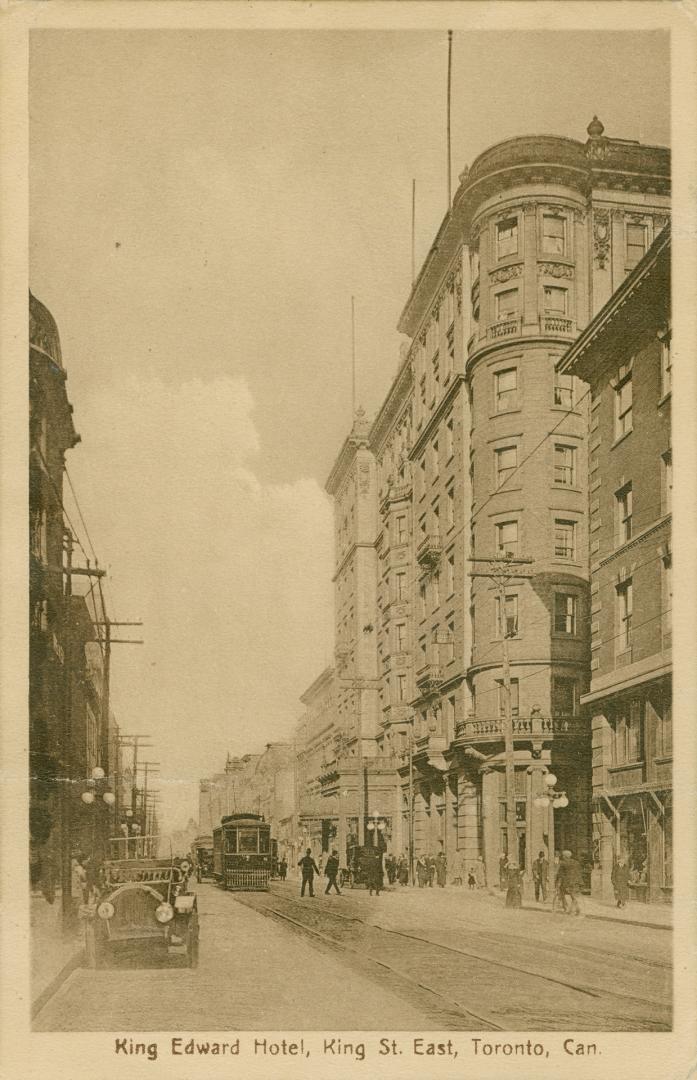 Sepia toned picture of the corner of an eight story hotel building on a downtown street.