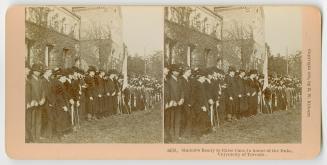 Pictures show a large university building with a huge line up of formally dressed men standing …