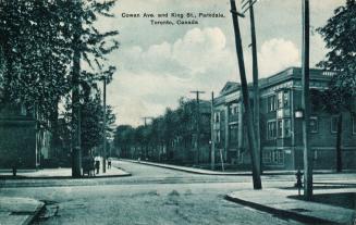 Blue tinted black and white picture of a street intersection with a large building with columns…