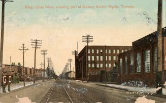 Colorized photograph of a city street with factories on either side.
