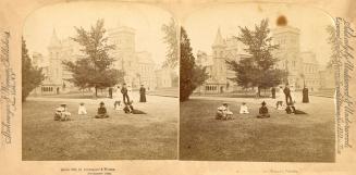 Pictures show people sitting on a lawn in front of a huge Victorian building with turrets and t…