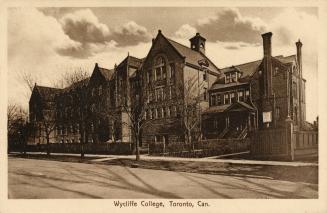 Sepia toned photograph of a four story school building immediately next to a large Victorian ho…