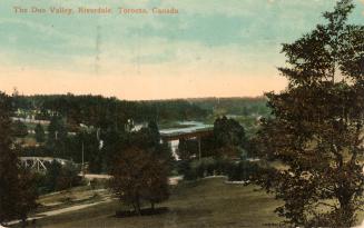 Colorized photograph of a long shot of a river with a railway bridge gong over it.
