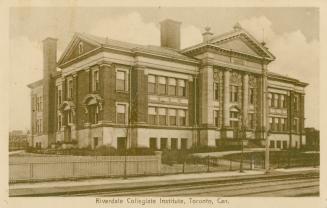 Sepia toned photograph of a three story school building with classical columns at the front doo…