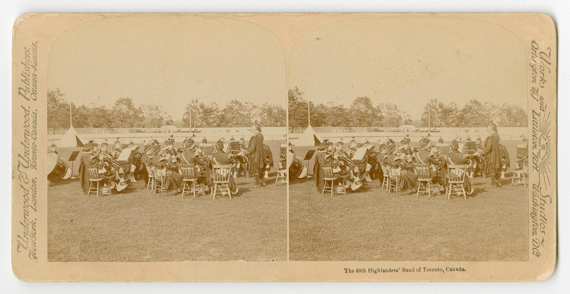 Pictures show members of a pipe and drum band sitting on chairs with their instruments in an ou…