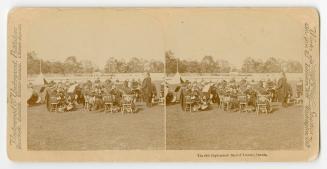 Pictures show members of a pipe and drum band sitting on chairs with their instruments in an ou…