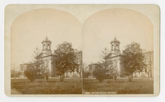 Pictures show a large gothic-romanesque style building with a central tower on a lawn with tree…