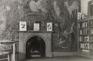 Picture of room with large mural on the wall and a fireplace with three books displayed on the …