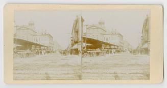 Pictures show covered market stalls with large city buildings behind them.