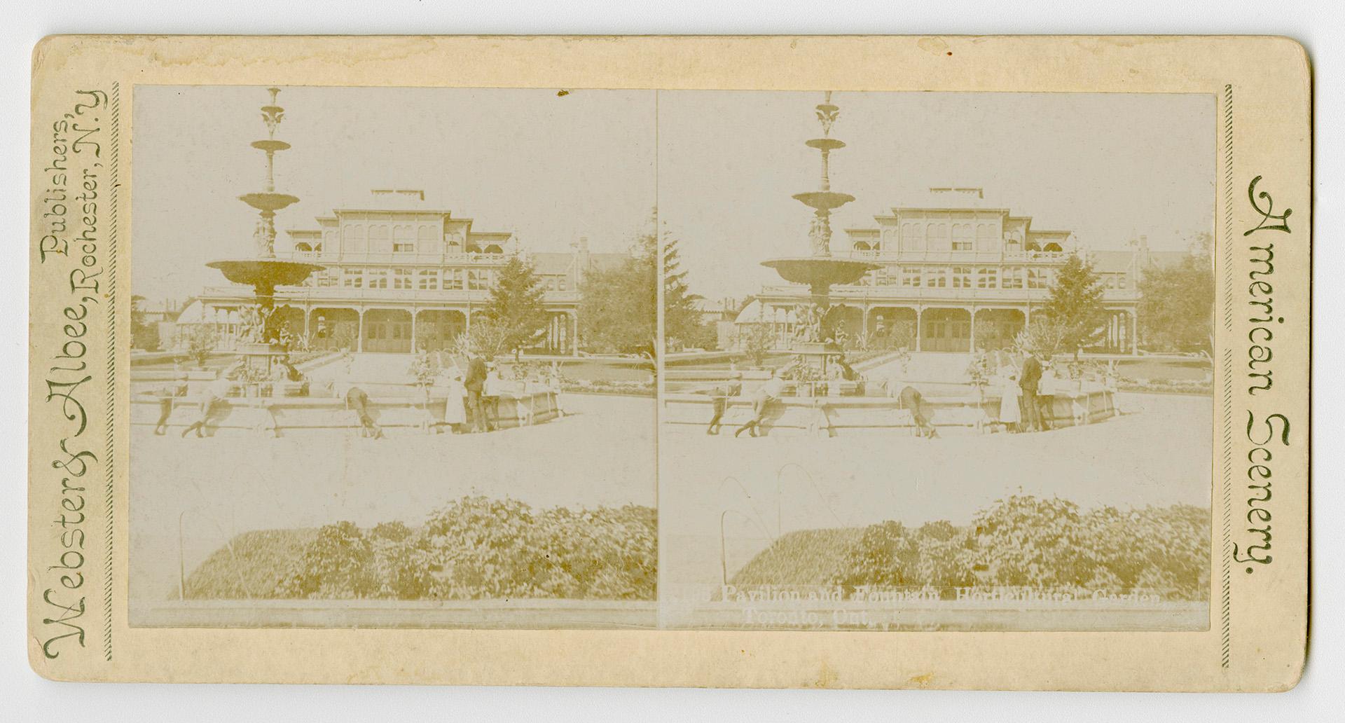 Pictures show a group of people standing around a huge fountain with a large public building be…